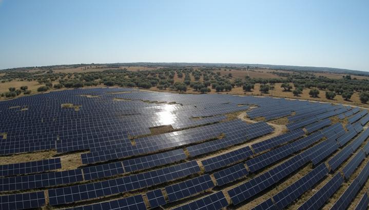 Zelestra привлекла €13 млн на солнечные проекты в Италии Солнечная электростанция с рядами фотоэлектрических панелей на холмистой местности в Италии под ясным солнечным небом.